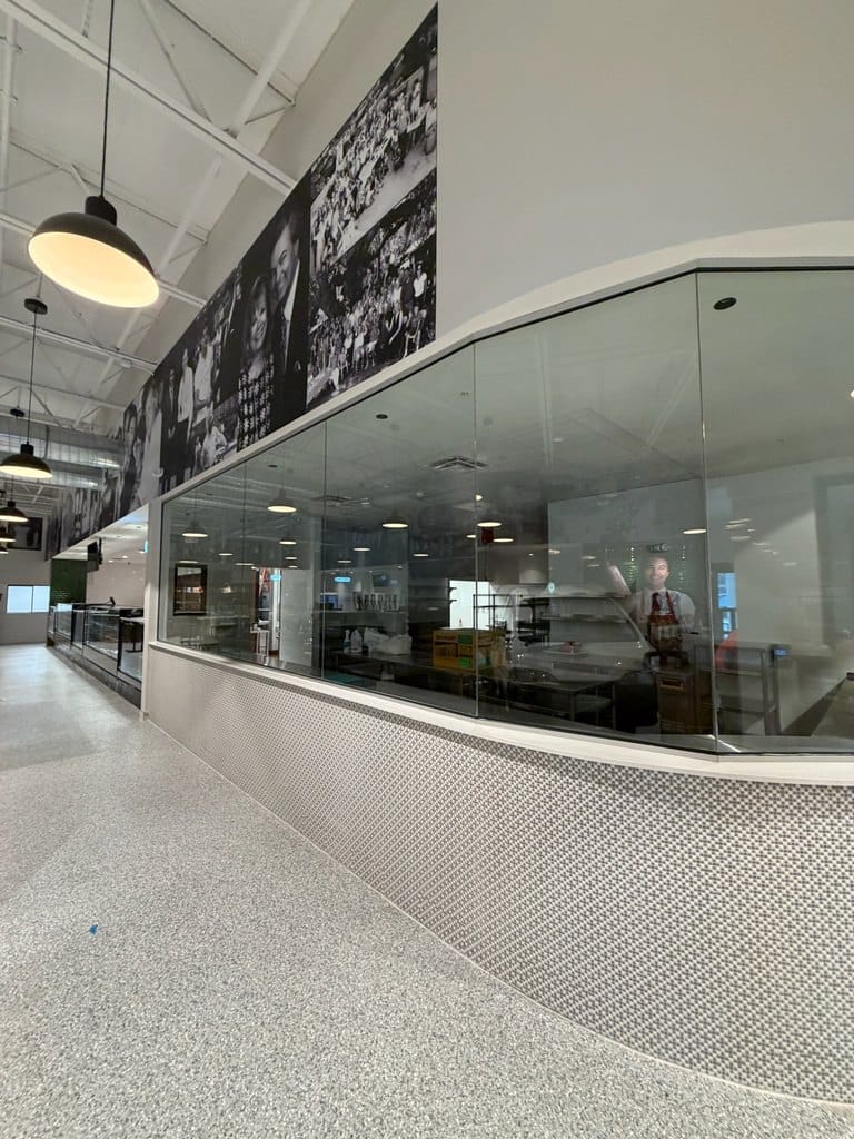 Curved glass wall showcasing the prep area at Alessi Bakery in Tampa